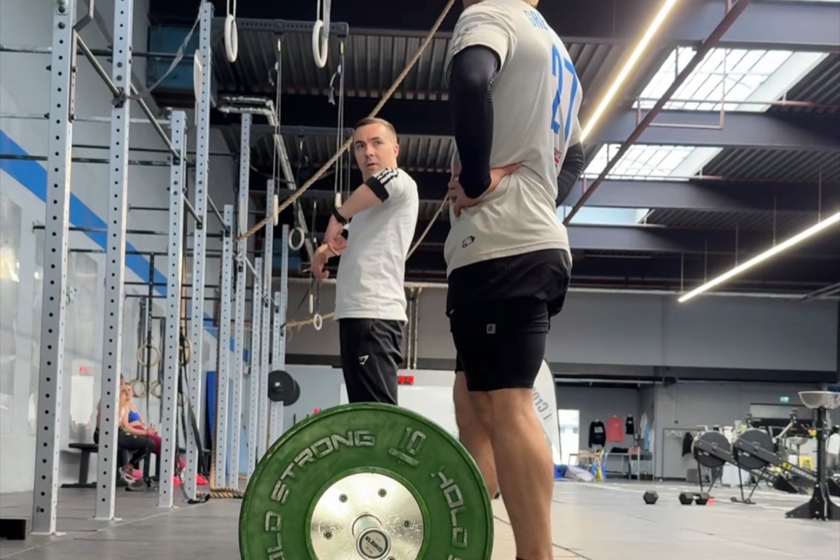 Ronnie Nolte gibt einem Athleten im Kraftraum Hinweise vor dem Kreuzheben