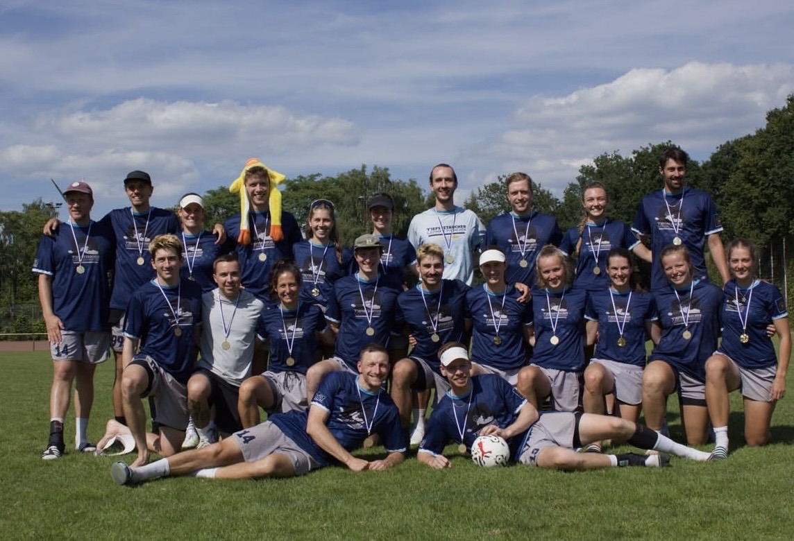 Mannschaftsfoto der Tiefseetaucher München mit Medaillen nach dem Gewinn der Deutschen Meisterschaft im Mixed Ultimate Frisbee